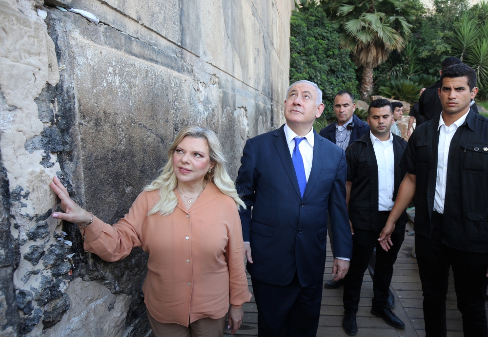 Israeli Prime Minister Benjamin Netanyahu looks up while his wife Sara touches the outside wall of the Cave of the Patriarchs, a shrine holy to Jews and Muslims during a state memorial ceremony, in Hebron in the Israeli-occupied West Bank September 4, 201
