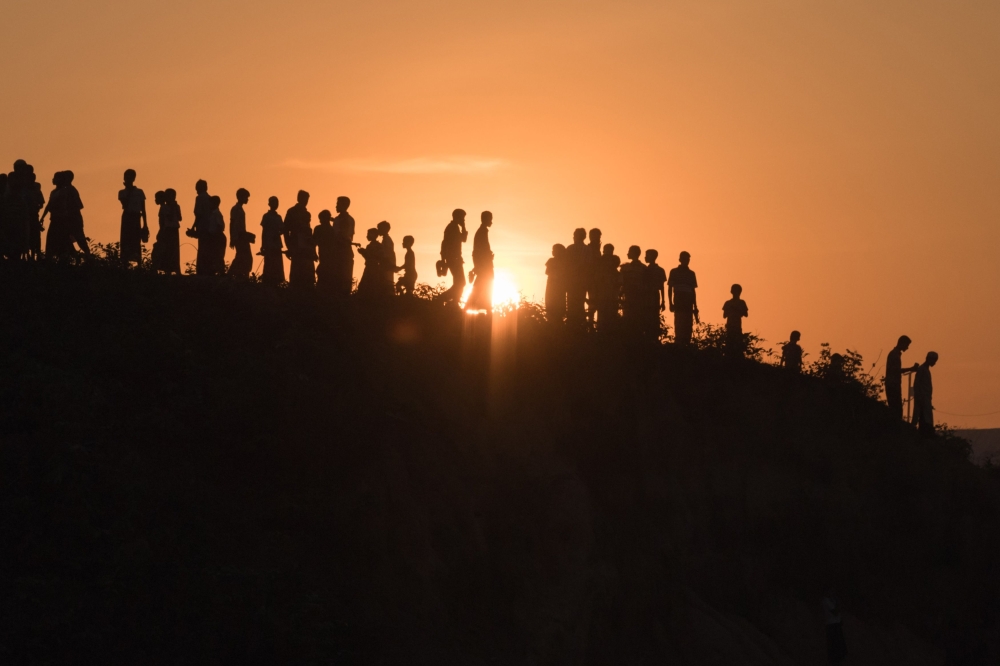In this file photo taken on November 26, 2017, Rohingya Muslim refugees walk down a hillside in the Kutupalong refugee camp in Bangladesh. AFP / Ed Jones
