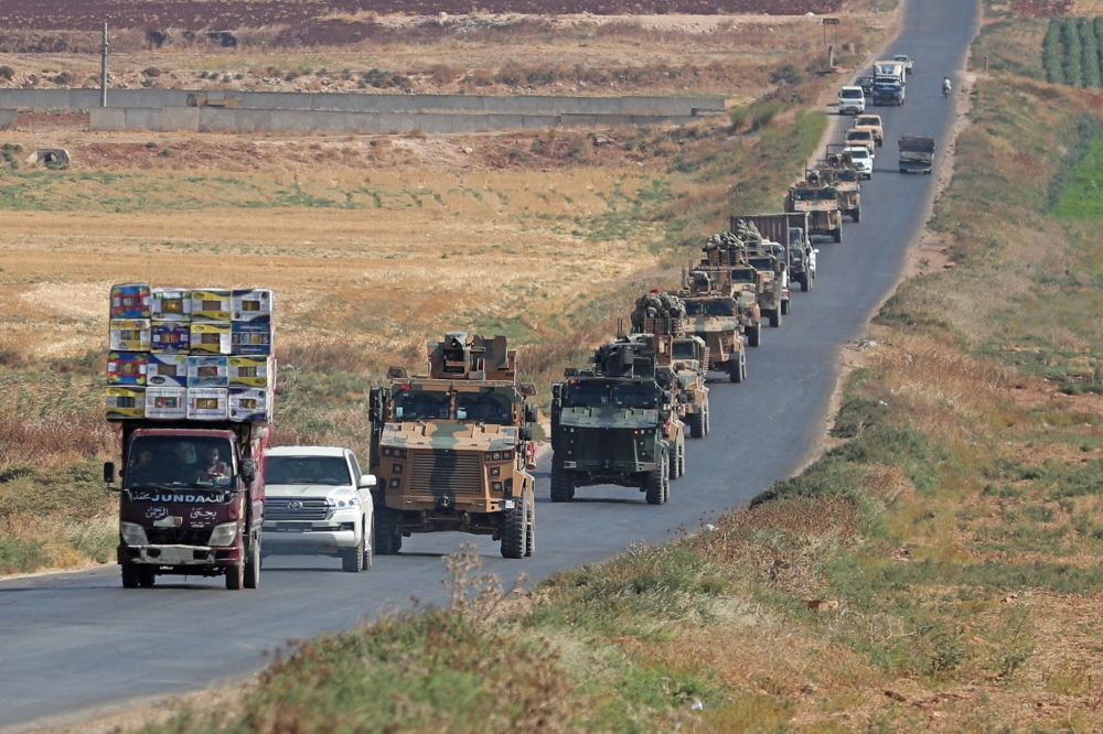 A convoy of Turkish military vehicles passing through the village of Kafr Halab on the western edge of Aleppo province. / AFP / Omar HAJ KADOUR