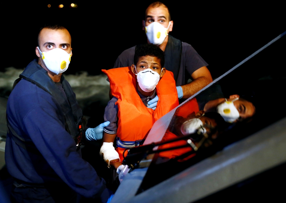 A Tunisian migrant is assisted by Armed Forces of Malta sailors during his medical evacuation to Malta from the German NGO Sea-Eye migrant rescue ship 'Alan Kurdi' in international waters off Malta in the central Mediterranean Sea, September 9, 2019. Reut