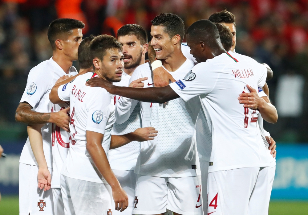 Portugal's Cristiano Ronaldo celebrates scoring their second goal with teammates. REUTERS/Ints Kalnins