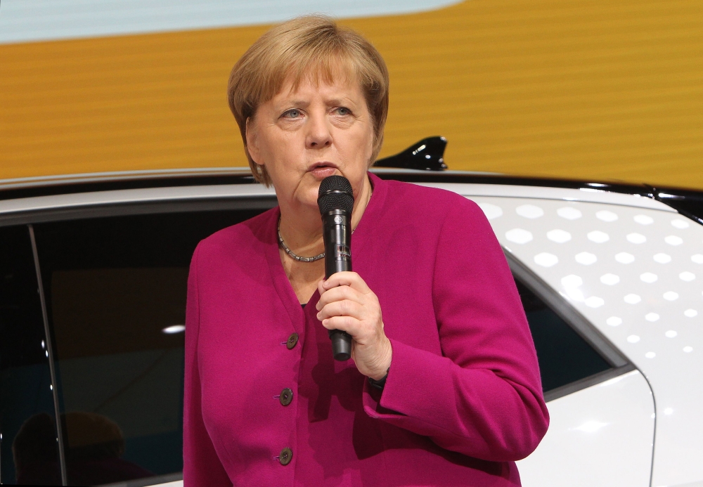 German Chancellor Angela Merkel speaks next to an ID.3 electric car as she visits the booth of German car giant Volkswagen (VW) during her opening tour at the IAA Car Show in Frankfurt on September 12, 2019. AFP / Daniel ROLAND
