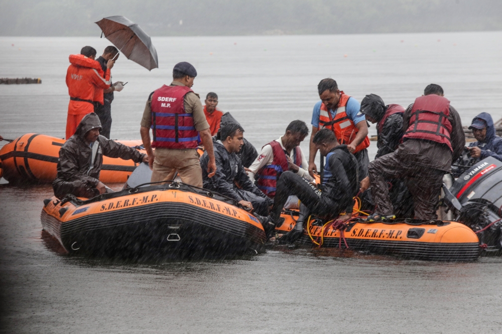 National Disaster Response Force (NDRF) and State Disaster Emergency Response Force (SDERF) personnel conduct rescue and search operations for survivors at Lower Lake in Bhopal on September 13, 2019, after boats overturn as they carry people and an idol o