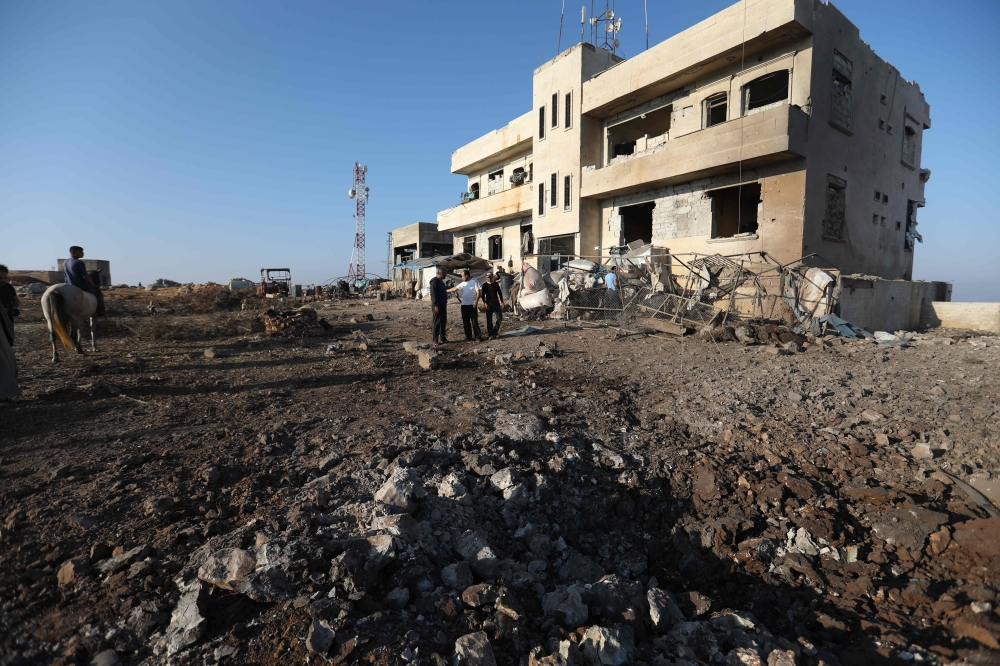 Syrian onlookers gather at the scene of a reported Russian airstrike in the village of al-Daher in Syria's northwestern Idlib province on September 11, 2019.   AFP / Omar HAJ KADOUR

