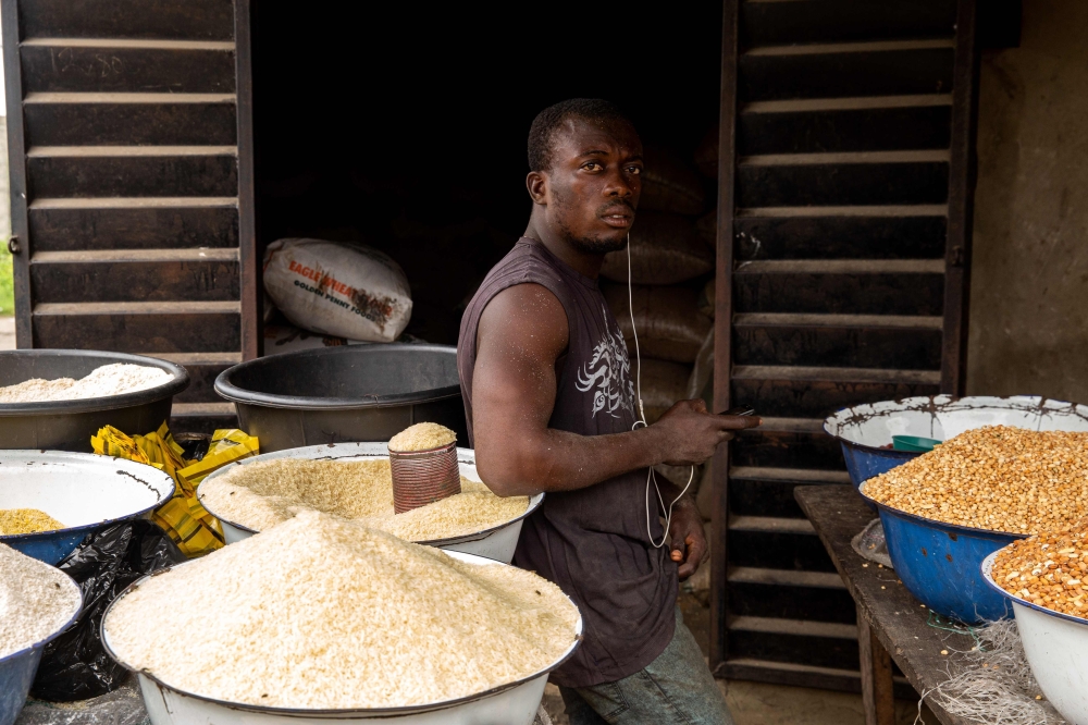 A Nigerian man poses next to some rice in his shop at Ajara Market in Badagry, near Lagos, on September 6, 2019.  AFP / Benson Ibeabuchi