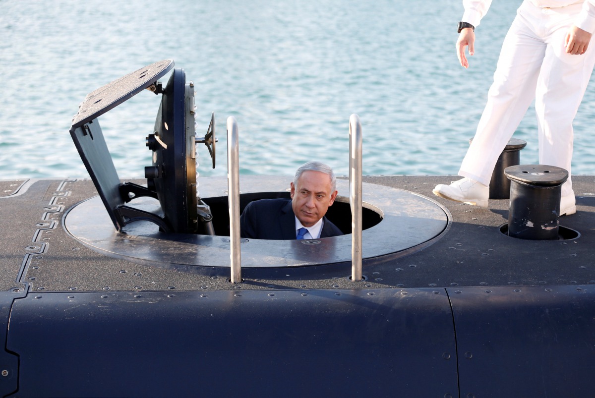Benjamin Netanyahu climbs out after a visit inside the Rahav, the fifth submarine, after it arrived in the Haifa port, January 12, 2016. Reuters/Baz Ratner
