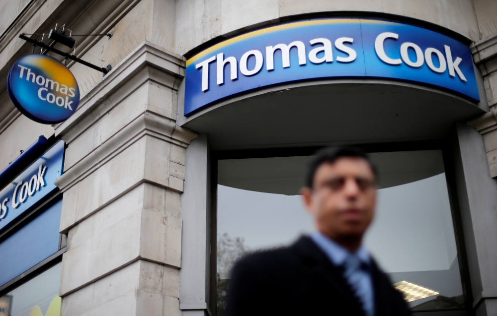 FILE PHOTO: A pedestrian walks past a Thomas Cook shop in central London, November 26, 2014. REUTERS/Suzanne Plunkett/File Photo