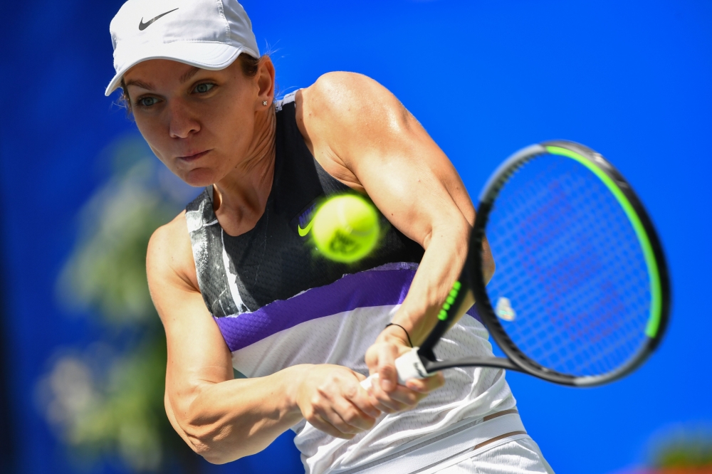 Simona Halep of Romania hits a return against Barbora Strycova of Czech Republic during their second-round women's singles match at the Wuhan Open tennis tournament in Wuhan on September 24, 2019. / AFP / HECTOR RETAMAL