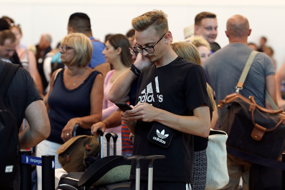 Tourists queue up in a check-in service at Cancun International Airport after Thomas Cook, the world's oldest travel firm, collapsed stranding hundreds of thousands of holidaymakers around the globe and sparking the largest peacetime repatriation effort i