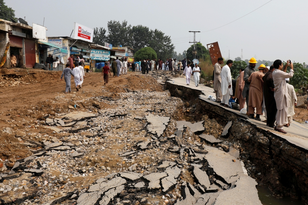 Residents walk along a road damaged during an earthquake in Jatlan, Mirpur, Pakistan September 25, 2019. REUTERS/Akhtar Soomro