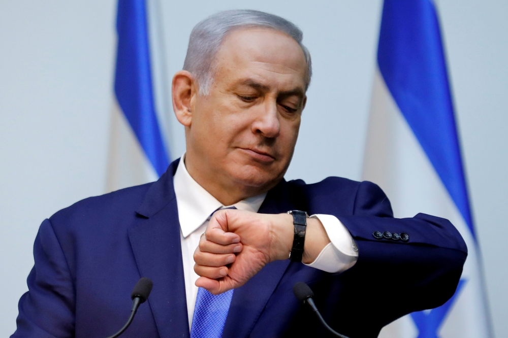 Israeli Prime Minister Benjamin Netanyahu looks at his watch before delivering a statement at the Knesset, Israel's parliament, in Jerusalem December 19, 2018. Reuters/Amir Cohen