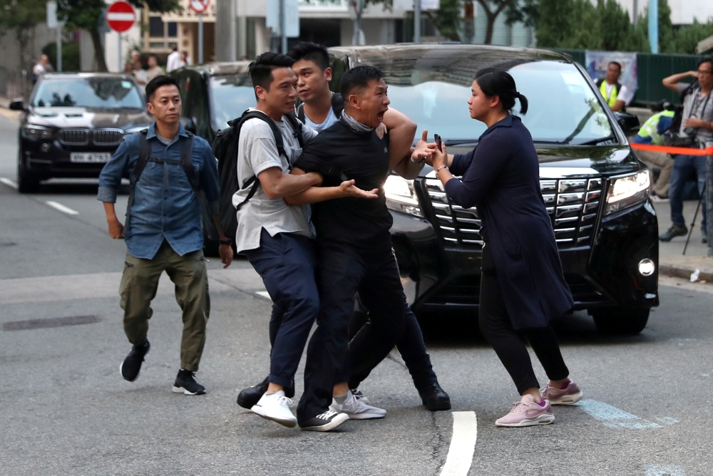 A protester is escorted by undercover police officers after he tried to stop Hong Kong Chief Executive Carrie Lam's motorcade in Hong Kong, China September 26, 2019. REUTERS/Athit Perawongmetha 