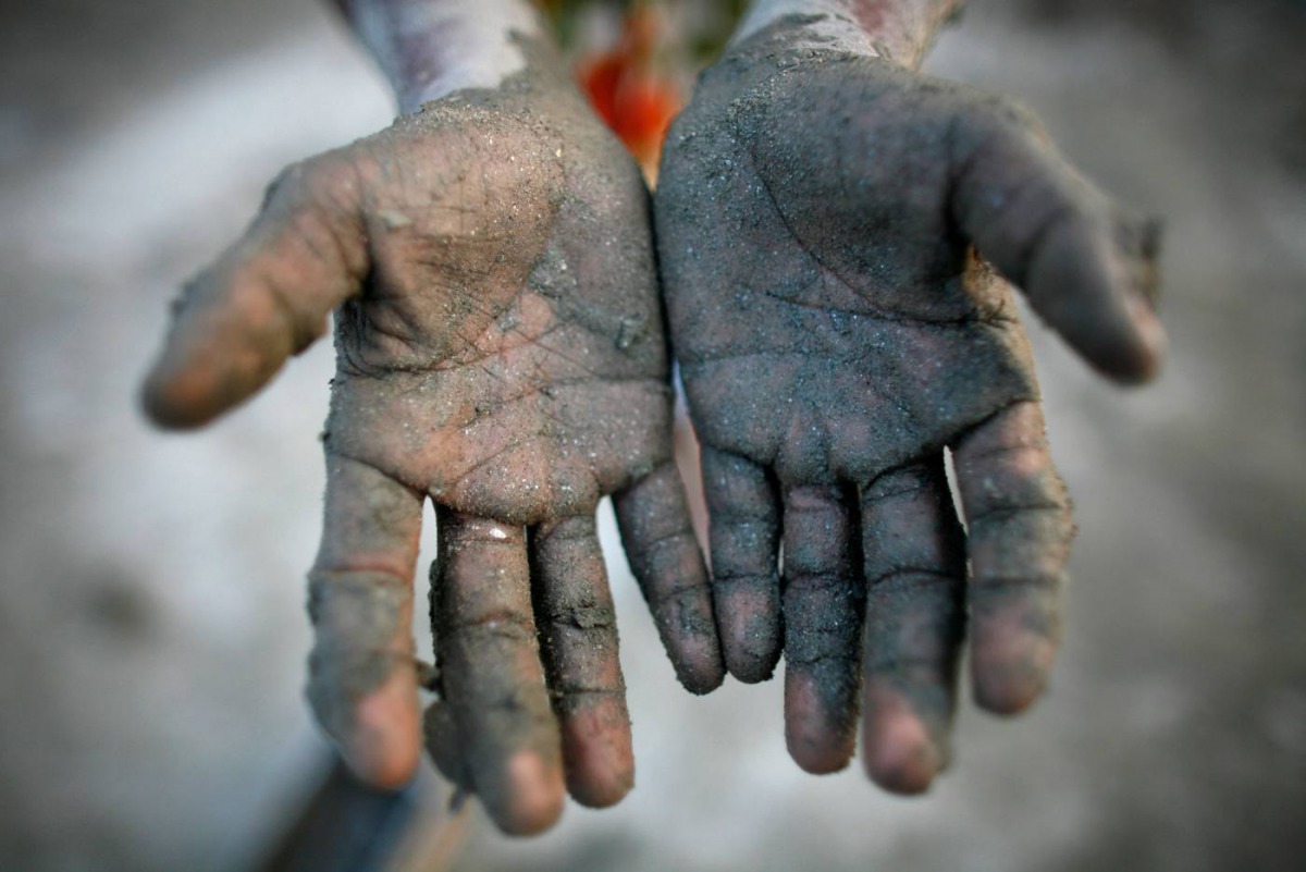 Tota Miya, 10, shows his hands after preparing soil to make bricks in a brick field on the outskirts of Dhaka November 21, 2009. Reuters/Andrew Bira