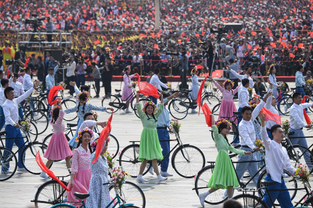 People take part in the National Day parade at Tiananmen Square in Beijing on October 1, 2019, to mark the 70th anniversary of the founding of the People’s Republic of China. / AFP / GREG BAKER