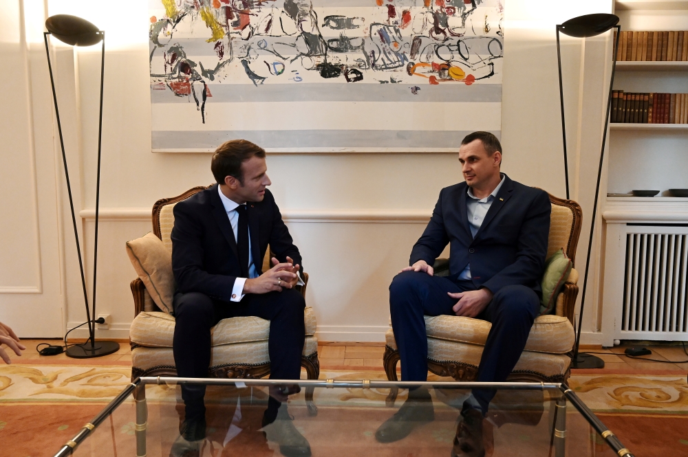 French President Emmanuel Macron speaks with Ukrainian film director Oleg Sentsov at the Permanent Representation of France to the Council of Europe in Strasbourg, France, on October 1, 2019. Frederick Florin/Pool via REUTERS