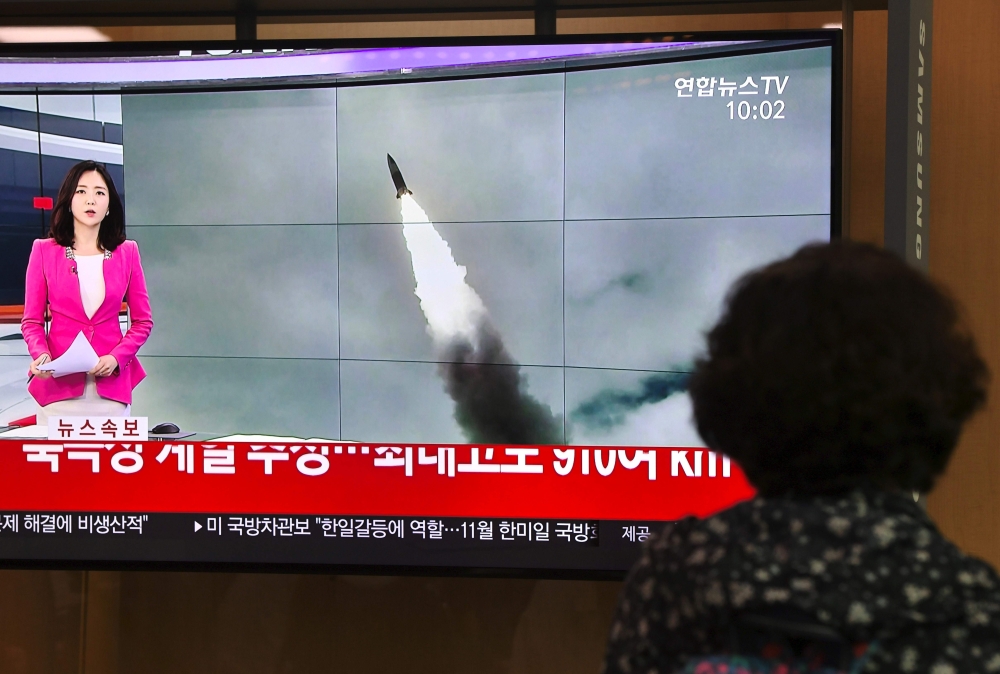 A woman watches a television news screen showing file footage of a North Korean missile launch, at a railway station in Seoul on October 2, 2019.   AFP / Jung Yeon-je