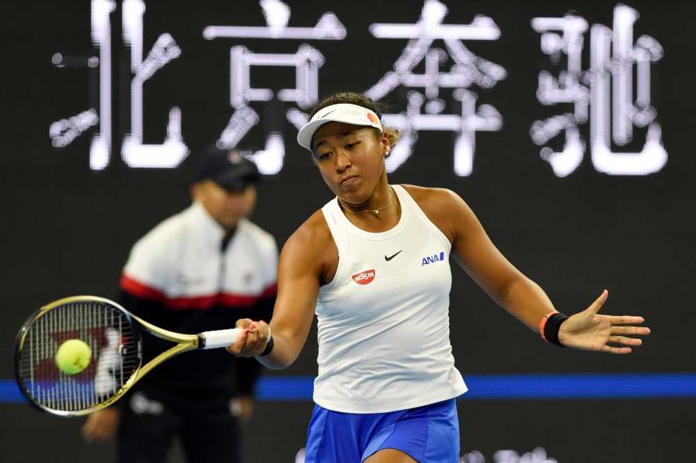 Naomi Osaka of Japan hits a return during her women's singles semi-final match against Caroline Wozniacki of Denmark at the China Open tennis tournament in Beijing on October 5, 2019. / AFP / Leo Ramirez 