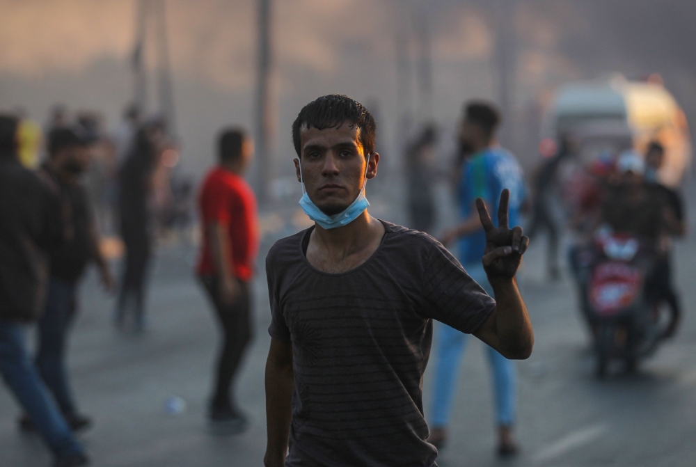 File photo of An Iraqi demonstrator gestures with the v-sign for victory during a demonstration against state corruption, failing public services, and unemployment, in the Iraqi capital Baghdad on October 5, 2019. / AFP / AHMAD AL-RUBAYE 