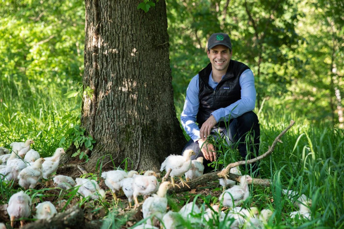 Cooks Venture CEO Matthew Wadiak with the company's heirloom chickens at their 800-acre farm in Arkansas, United States. Photo Credit: Cooks Venture