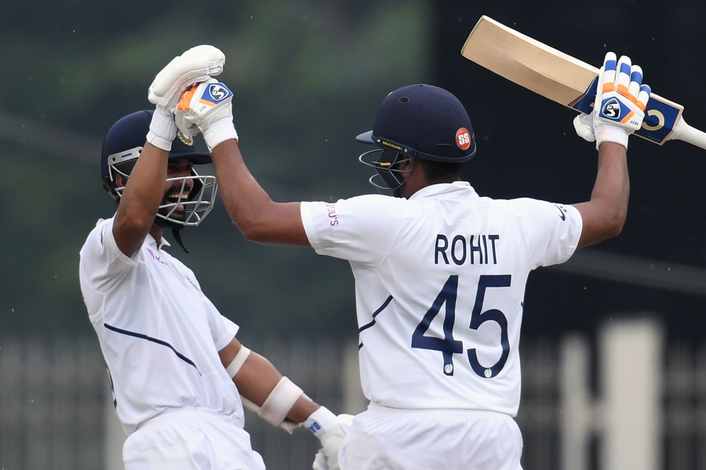 India's Rohit Sharma (R) celebrates his century (100 runs) with teammate Ajinkya Rahane during the first day of the third and final Test match between India and South Africa at the Jharkhand State Cricket Association (JSCA) stadium in Ranchi on October 19
