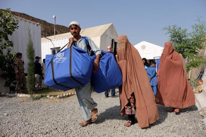 An Afghan family who were living as refugees in Pakistan carries bundles of supplies at a humanitarian aid station in Torkham, Afghanistan, October 22, 2016. Reuters / Josh Smith