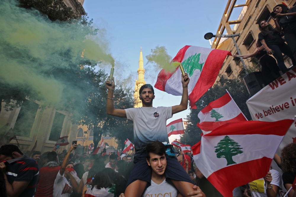 Lebanese protesters take to the streets during demonstrations to demand better living conditions and the ouster of a cast of politicians who have monopolised power and influence for decades, on October 21, 2019 at Riad al-Solh Square in Beirut.  AFP / Anw