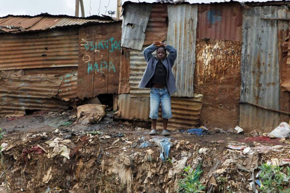 A child stands behind pit latrines made of rusted iron sheets in Kibera slum within Nairobi, Kenya, February 24, 2019. Reuters / Njeri Mwangi