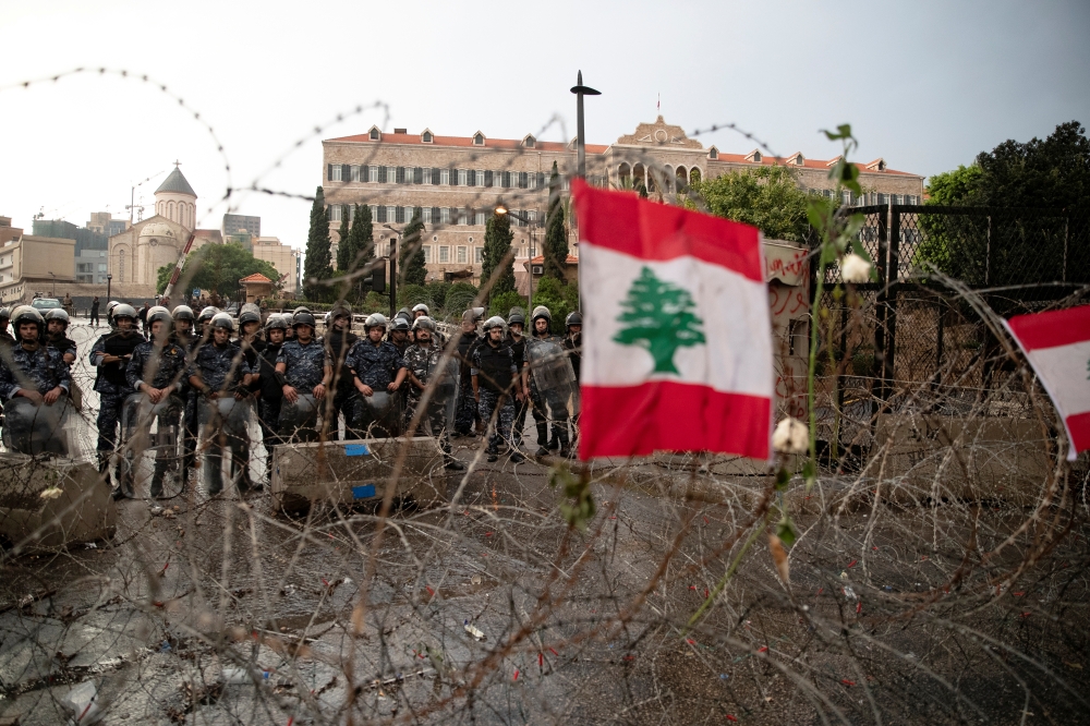 Riot police stand guard behind barbed-wire next to the Government Palace during ongoing anti-government protests in downtown Beirut, Lebanon, October 24, 2019. Reuters/Alkis Konstantinidis
 