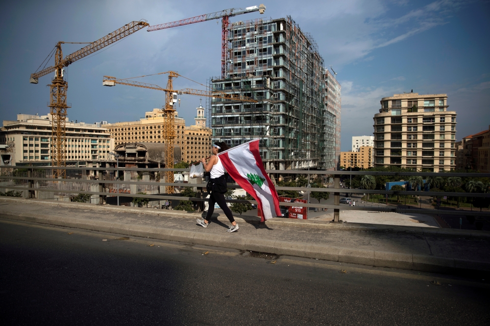 A demonstrator carries a Lebanese national flag during ongoing anti-government protests in downtown Beirut, Lebanon, October 28, 2019. REUTERS/Alkis Konstantinidis