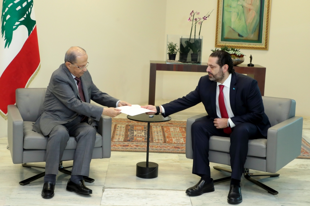 Prime Minister Saad Hariri (R) hands President Michel Aoun his government's resignation at the Baabda presidential palace, east of the capital Beirut, on October 29, 2019, bowing to nearly two weeks of unprecedented nationwide protests. AFP / Dalati And N