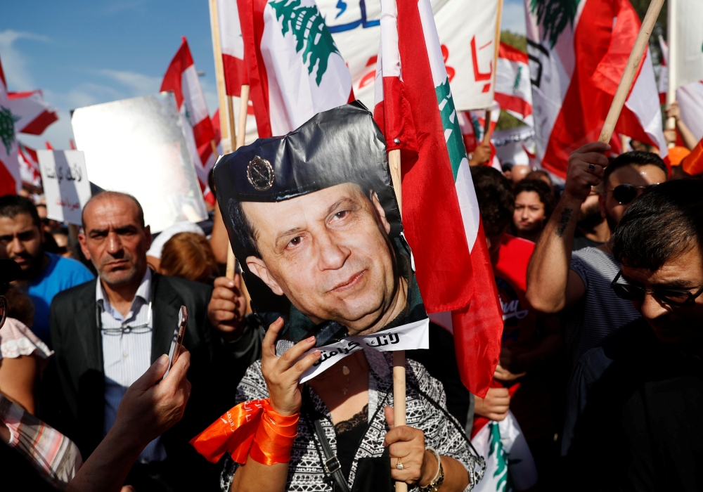 A supporter of Lebanon's President Michel Aoun holds his pictures during a rally in Baabda near Beirut, Lebanon, November 3, 2019. REUTERS/Goran Tomasevic
 