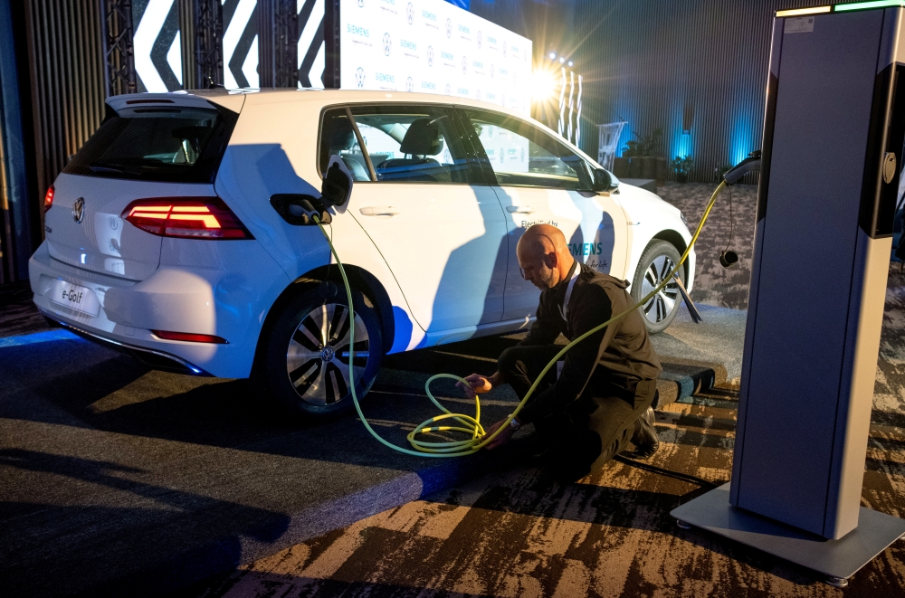 A member of staff charges a Volkswagen e-Golf electric car during its launch for use in its ride-hailing service in Kigali, Rwanda October 29, 2019. REUTERS/Jean Bizimana