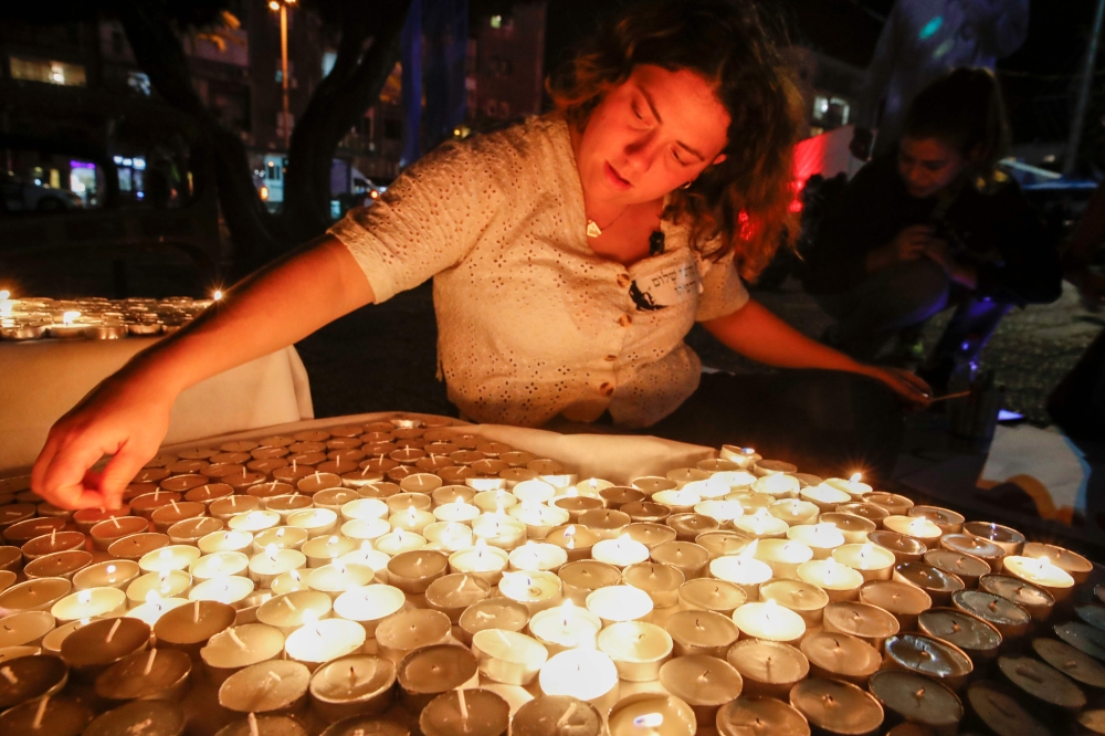 Israelis light candles during a rally to mark the 24nd anniversary of the assassination of former Israeli prime minister Yitzhak Rabin at Rabin Square, in the coastal city of Tel Aviv on November 2, 2019.  AFP / Jack Guez
 