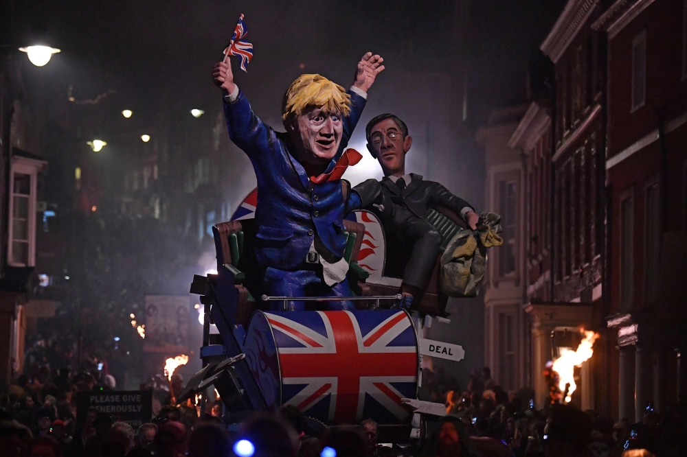 Effigies of Britain's Leader of the House of Commons Jacob Rees-Mogg (R) and Britain's Prime Minister Boris Johnson are paraded through the streets of Lewes in East Sussex, southern England, on November 5, 2019, during the traditional Bonfire Night celebr