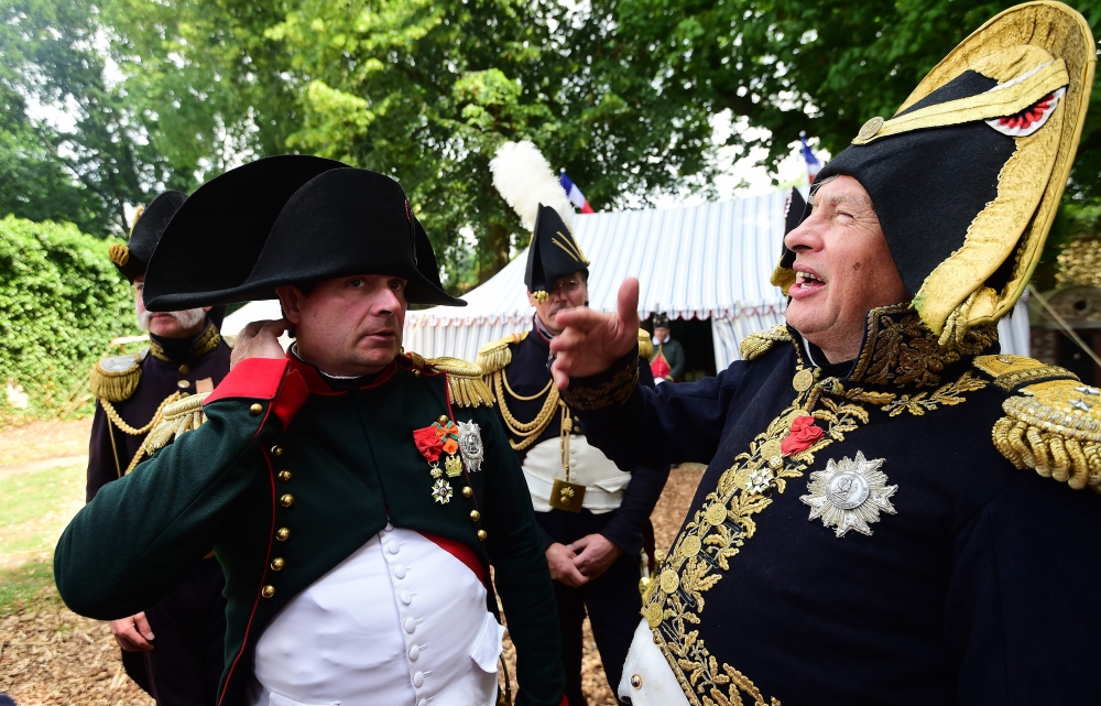 (FILES) This file photo taken on June 18, 2015 shows French lawyer Franck Samson, dressed as Napoleon Bonaparte (L) speaking with Russian historian Oleg Sokolov (R) during commemorations marking the 200th anniversary of The Battle of Waterloo in Waterloo.