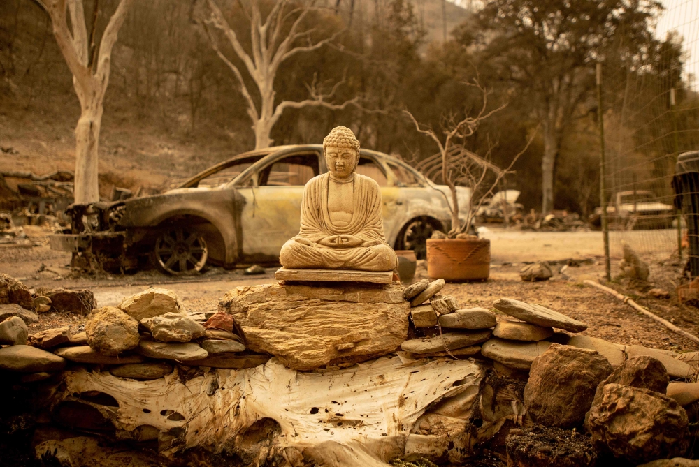 A Buddha statue is seen at a burned home in Spring Valley near Clearlake Oaks, northern California on August 7, 2018. AFP / Josh Edelson