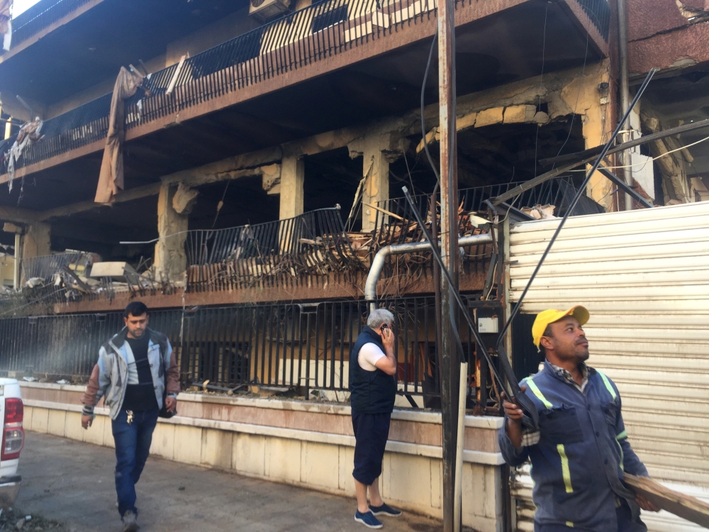 Men walk past a damaged building in Mezzah, Damascus, Syria November 12, 2019. REUTERS/Omar Sanadiki