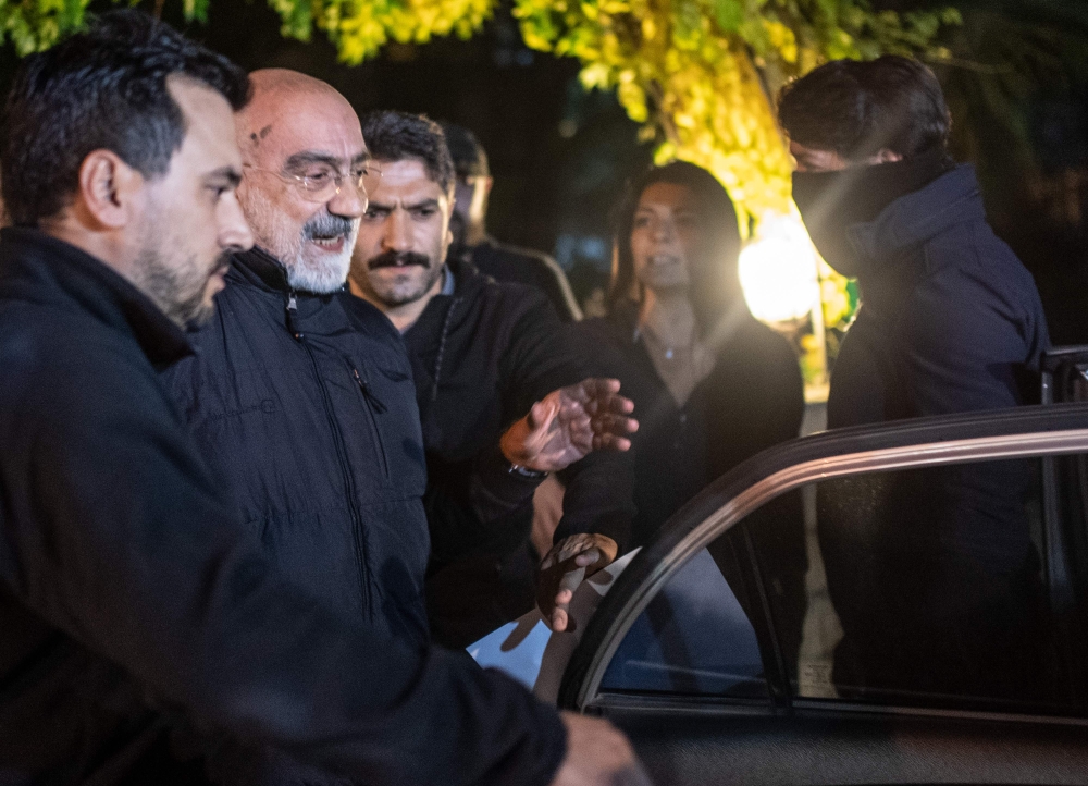 Journalist and writer Ahmet Altan (C) walks with Turkish police as his daughter Senem Altan (R) tries to say him goodbye as he is detained on November 12, 2019, at Kadikoy neighbourhood in Istanbul./ AFP / BULENT KILIC 