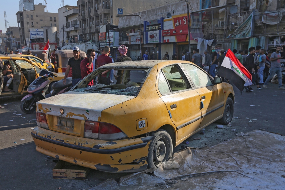 Iraqis gather at the site of a bomb explosion near Baghdad's Tahrir Square on November 16, 2019.   AFP / SABAH ARAR