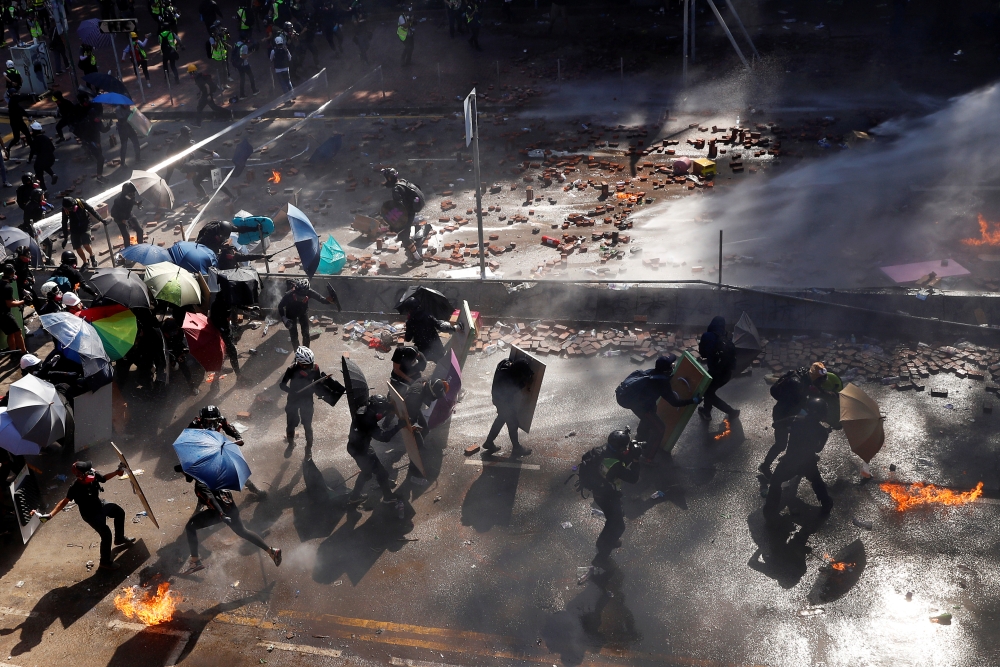 Protesters are sprayed with water from water cannon during clashes with police outside Hong Kong Polytechnic University (PolyU) in Hong Kong, China November 17, 2019. REUTERS/Thomas Peter