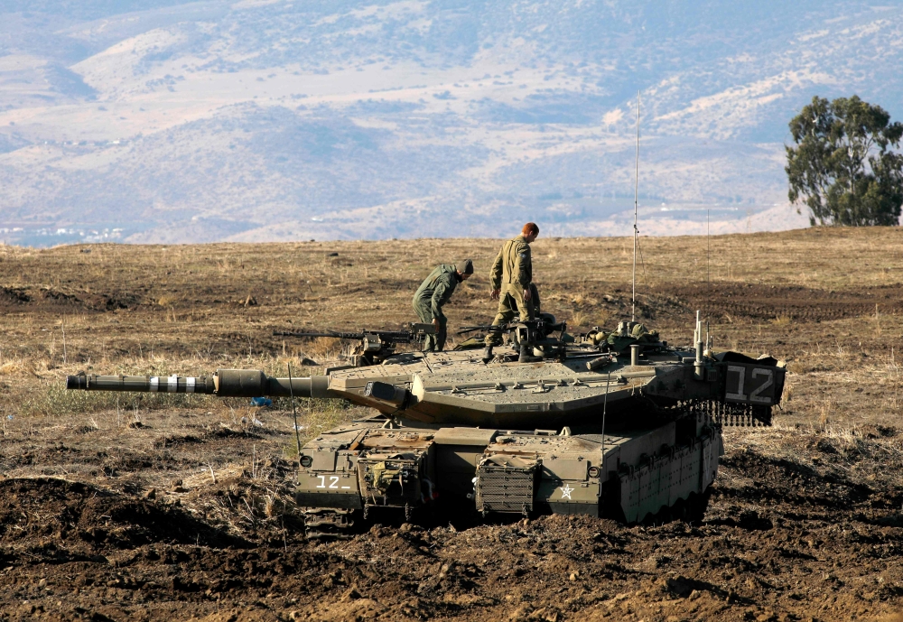 Israeli soldiers and armoured vehicles are pictured on November 19, 2019 near the border with Syria in the annexed Golan Heights. AFP / JALAA MAREY