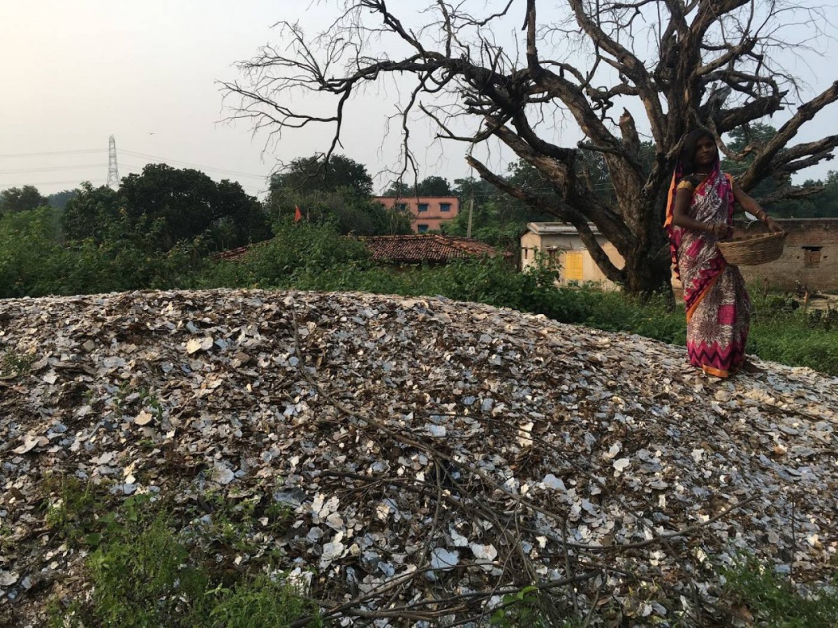 A woman stands atop a pile of mica in Giridih, India, on October 16, 2019. Thomson Reuters Foundation/Roli Srivastava 