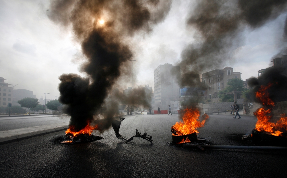 FILE PHOTO: Smoke rises from tyres set ablaze by anti-government rioters on a main road near a government building in Beirut May 7, 2008. REUTERS/Jamal Saidi/File Photo