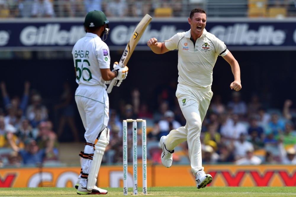 Australia's paceman Josh Hazlewood (R) celebrates his wicket of Pakistan's Babar Azam (L) on day one of the first Test cricket match between Pakistan and Australia at the Gabba in Brisbane on November 21, 2019. - / AFP / AFP / Saeed KHAN