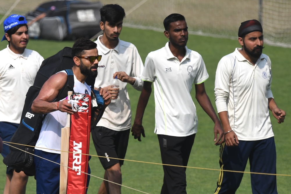 India's cricket team captain Virat Kohli (2nd L) walks after a practice session at The Eden Gardens cricket stadium in Kolkata on November 21, 2019, ahead of the second Test cricket match between India and Bangladesh. / AFP / Dibyangshu SARKAR 