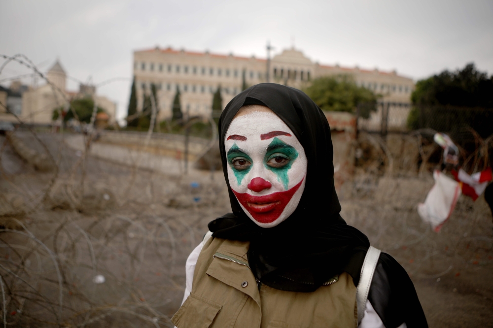 A Lebanese woman with her face painted with the character of the Joker takes part in a protest in downtown Beirut on October 23, 2019. AFP / Patrick Baz