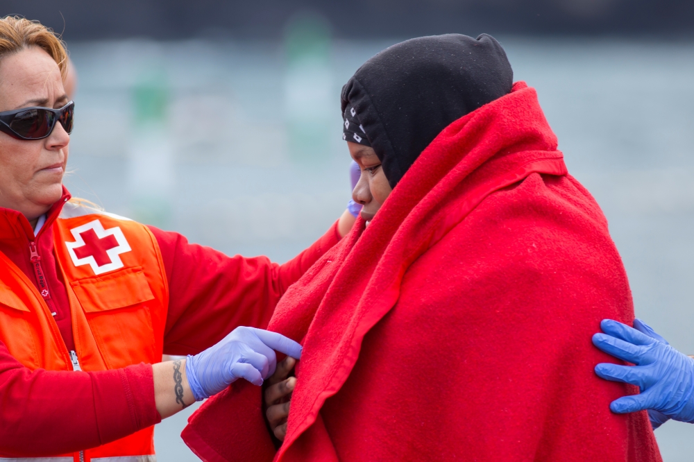 A pregnant woman is helped by a member of medical staff after arriving aboard a Spanish maritime rescue boat, after being rescued at sea north of Spain's Canary Islands, on the island of Las Palmas de Gran Canaria, Spain, November 22, 2019. Reuters/Borja 