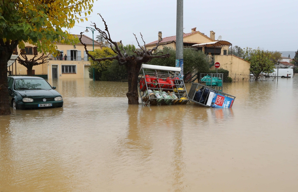 A car and gas tanks sit in water in a flooded area after heavy rains in Le Muy, southeastern France, on November 24, 2019.   AFP / Valery HACHE
