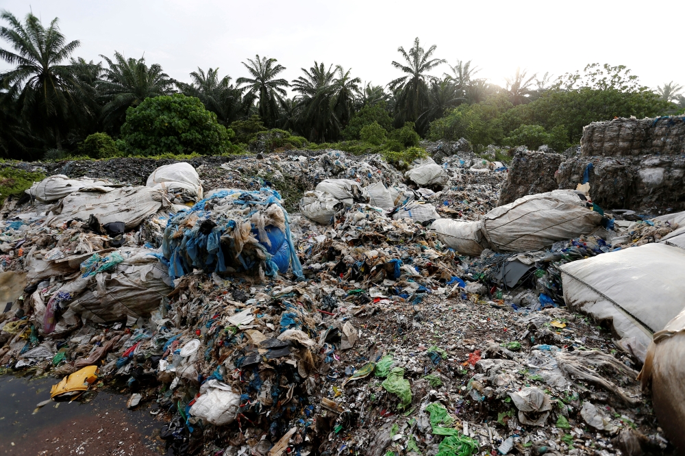 FILE PHOTO: FILE PHOTO: Scrap from an illegal plastic recycling factory are dumped near a palm oil plantation in Jenjarom, Kuala Langat, Malaysia October 14, 2018. Picture taken October 14, 2018. REUTERS/Lai Seng Sin/File Photo/File Photo