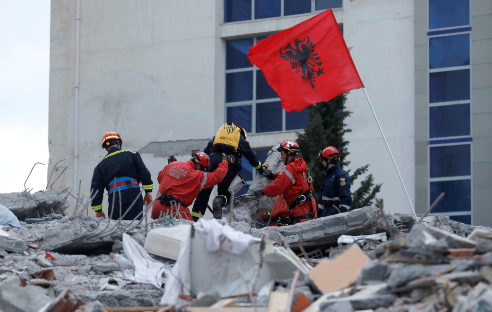 Emergency personnel put an Albanian flag on top of rubble, on the occasion of the Albanian Independence Day, during a search for survivors in a collapsed building in Durres, after an earthquake shook Albania, November 28, 2019. Reuters/Florion Goga